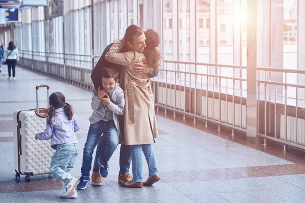 Pleine longueur de femme heureuse et deux petits enfants rencontrant père à l'aéroport — Photo