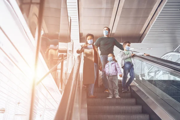 Rodina se dvěma malými dětmi pohybující se eskalátorem v letištním terminálu — Stock fotografie