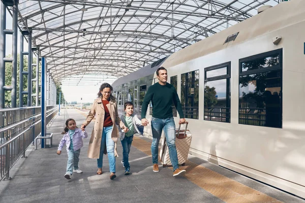 Plná délka rodiny se dvěma malými dětmi kráčející podél nástupiště železniční stanice společně — Stock fotografie