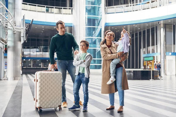 Toute la famille avec deux petits enfants en attente de leur vol au terminal de l'aéroport — Photo
