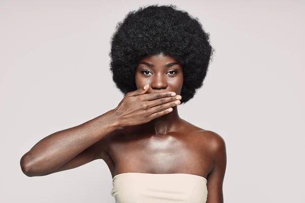 Retrato de una hermosa joven africana cubriendo la boca con la mano — Foto de Stock