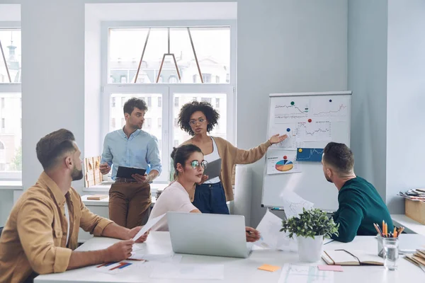 Groep van zelfverzekerde jongeren in slimme casual wear bespreken zaken tijdens een vergadering in het kantoor — Stockfoto