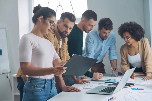 Equipo de negocios seguro que tiene una reunión rápida mientras está de pie cerca del escritorio de la oficina juntos —  Fotos de Stock