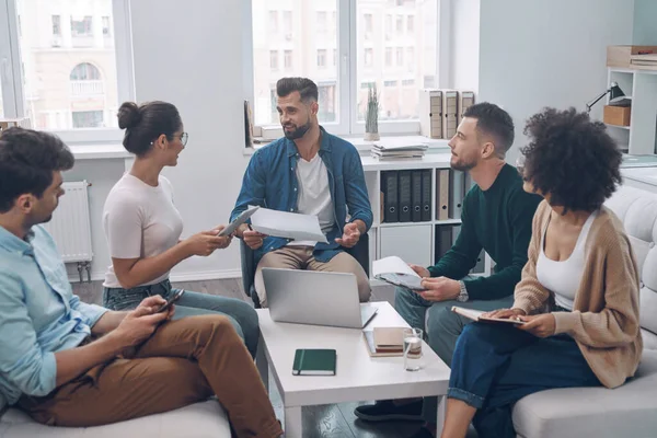 Equipe de negócios confiante tendo reunião enquanto sentados no escritório juntos — Fotografia de Stock