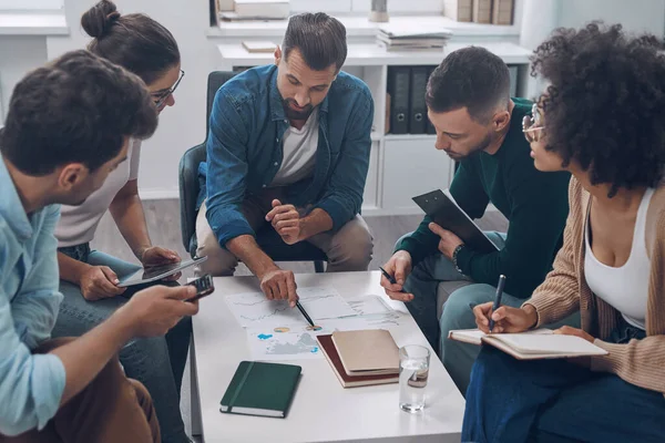 Top view of confident business team analyzing data while sitting in the office together — Stock Photo, Image