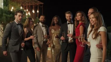 Formalite icabı giyinmiş bir grup mutlu insan konfetiyle eğleniyor. 