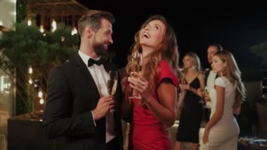 Genç ve güzel bir çift şampanya içerken lüks bir partide vakit geçiriyorlar. 