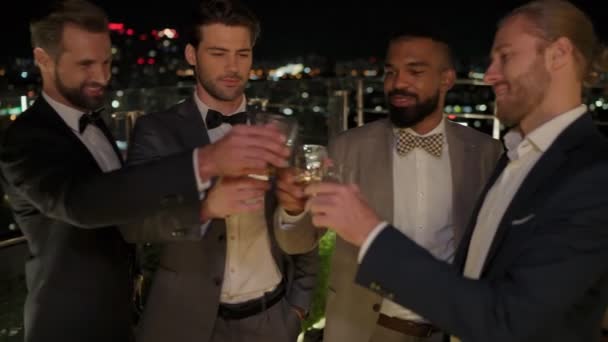 Group of handsome young men in suits spending time on rooftop party — Stock Video