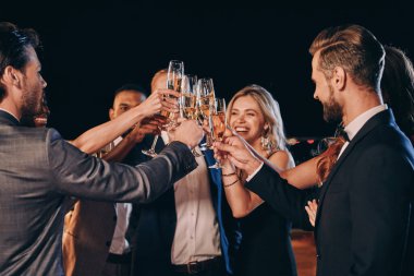 Group of beautiful people in formalwear toasting with champagne and smiling while spending time on luxury party clipart