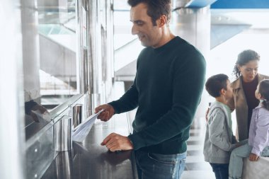 Bilet gişesinden bilet alan iki çocuklu bir aile.