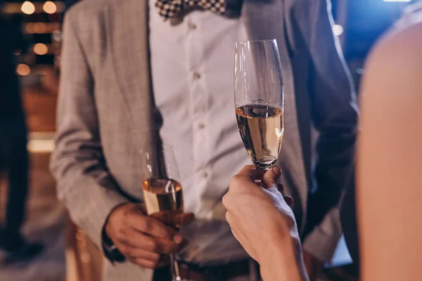 Close-up de casal bem vestido segurando flautas de champanhe — Fotografia de Stock