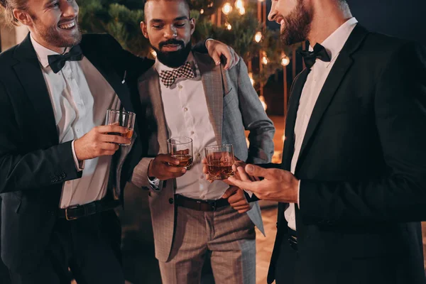 Drei gut gekleidete Männer trinken Whiskey und kommunizieren, während sie Zeit auf einer Party verbringen — Stockfoto