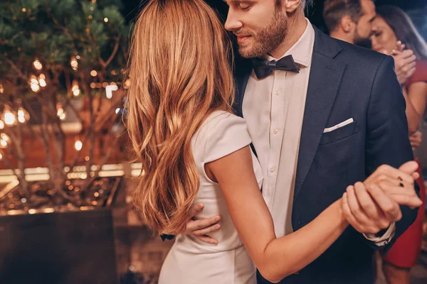 Hermosos jóvenes bailando y sonriendo mientras pasan tiempo en una fiesta de lujo — Foto de Stock