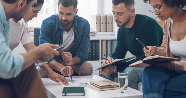 Sekelompok anak muda modern mendiskusikan bisnis sambil duduk di kantor bersama-sama — Stok Foto