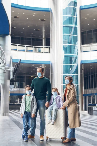 Una familia con dos niños esperando su vuelo en la terminal del aeropuerto — Foto de Stock