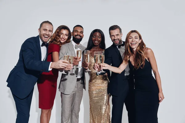 Gruppe schöner Menschen in Formalbekleidung prostet mit Champagner zu und lächelt — Stockfoto