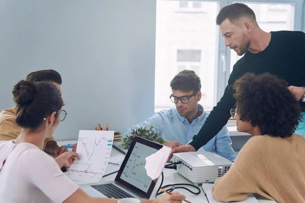 Gruppe selbstbewusster junger Leute in schicker Freizeitkleidung diskutiert Geschäfte, während sie sich im Büro treffen — Stockfoto