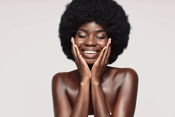 Yüzüne dokunan ve gülümseyen güzel bir Afrikalı kadının portresi. — Stok fotoğraf