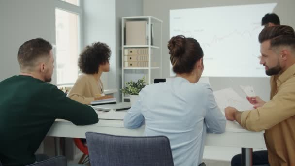 Grupo de jóvenes en ropa casual inteligente analizando datos en la pantalla de proyección — Vídeos de Stock