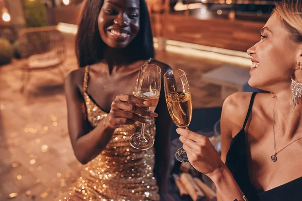 Duas mulheres bonitas em vestidos de noite brindar com champanhe e sorrindo — Fotografia de Stock