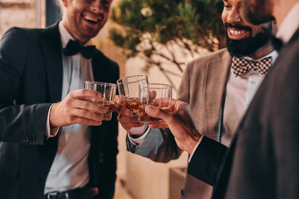 Primo piano di tre uomini ben vestiti che bevono whisky e comunicano mentre trascorrono del tempo alla festa — Foto Stock