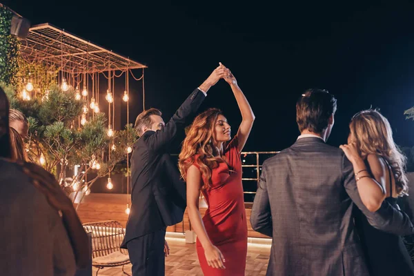 Hermosos jóvenes bailando y sonriendo mientras pasan tiempo en una fiesta de lujo — Foto de Stock