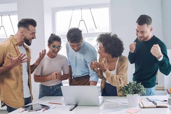 Grupp glada affärsmän i smart casual slitage hålla händerna tillsammans och ler — Stockfoto