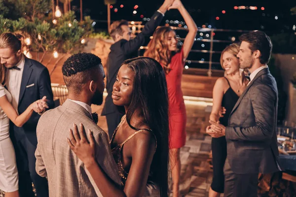 Vackra unga människor dansar och ler medan de tillbringar tid på lyxfest — Stockfoto