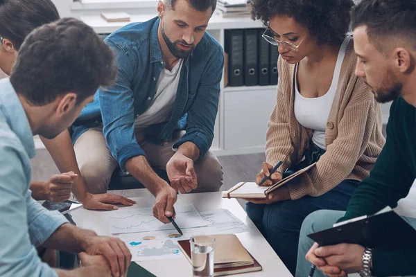 Top view of confident business team analyzing data while sitting in the office together — Stock Photo, Image