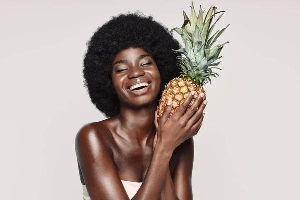 Portré gyönyörű fiatal afrikai nő kezében ananász és mosolygós — Stock Fotó