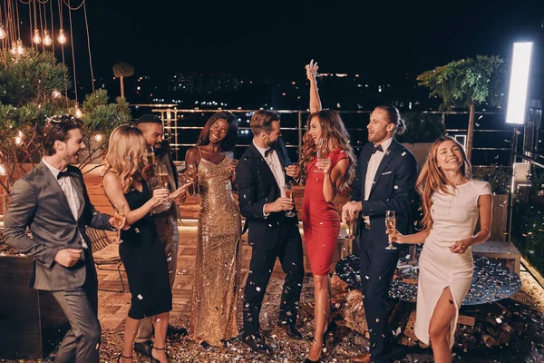 화려 한 복장을 한 행복 한 사람들이 함께 춤을 추며 콘 페티 와 함께 즐거운 시간을 보내고 있다 — 스톡 사진