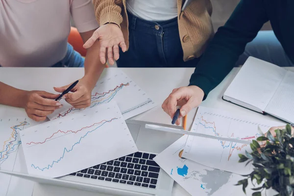 Vista dall'alto da vicino delle persone moderne in smart casual che analizzano i dati mentre si riuniscono in ufficio — Foto Stock