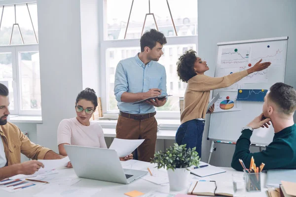 Groep van zelfverzekerde jongeren in slimme casual wear bespreken zaken tijdens een vergadering in het kantoor — Stockfoto