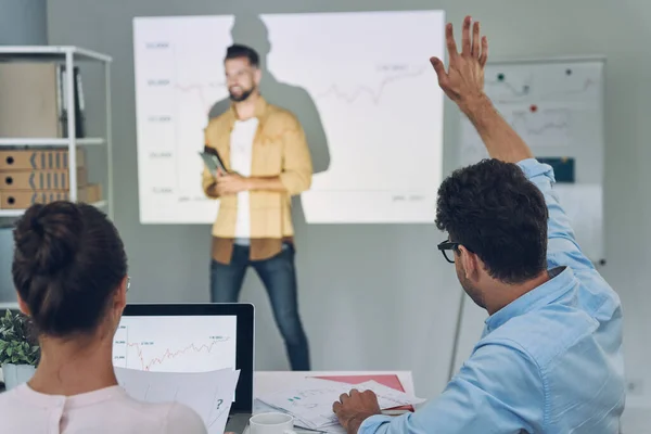 Groep van jonge moderne mensen in slimme casual wear analyseren van gegevens op projectiescherm in het kantoor — Stockfoto