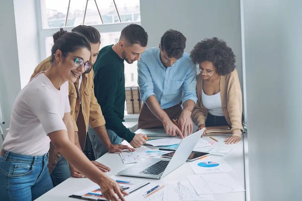 Equipo de negocios seguro que tiene una reunión rápida mientras está de pie cerca del escritorio de la oficina juntos —  Fotos de Stock