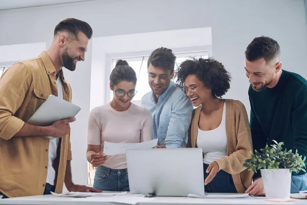 Gruppe selbstbewusster junger Leute in schicker Freizeitkleidung diskutiert Geschäfte, während sie sich im Büro treffen — Stockfoto