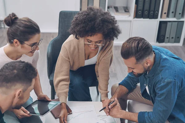 Vista dall'alto di un team aziendale sicuro che analizza i dati mentre si siede in ufficio insieme — Foto Stock