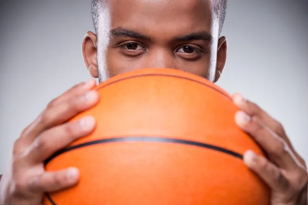 African man hiding  face behind basketball ball — Stock Photo, Image