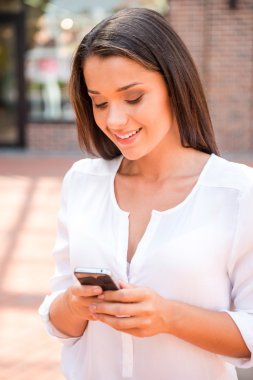 cep telefonu tutan genç gülümseyen kadın