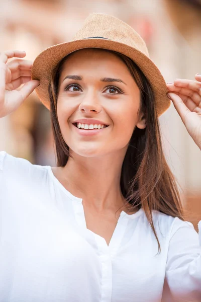 Mulher ajustando seu chapéu e sorrindo — Fotografia de Stock