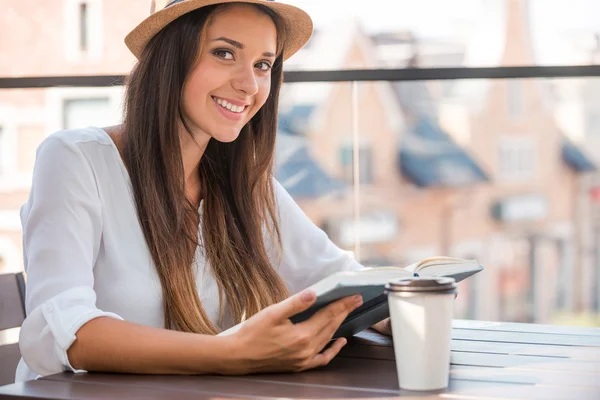 Vrouw in funky hoed lezen van boek — Stockfoto