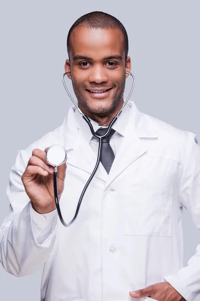 African doctor stretching out his stethoscope — Stock Photo, Image