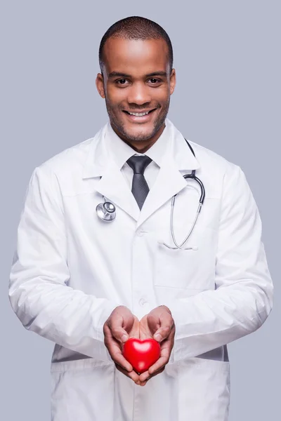 Африканский врач держит игрушку в форме сердца — стоковое фото