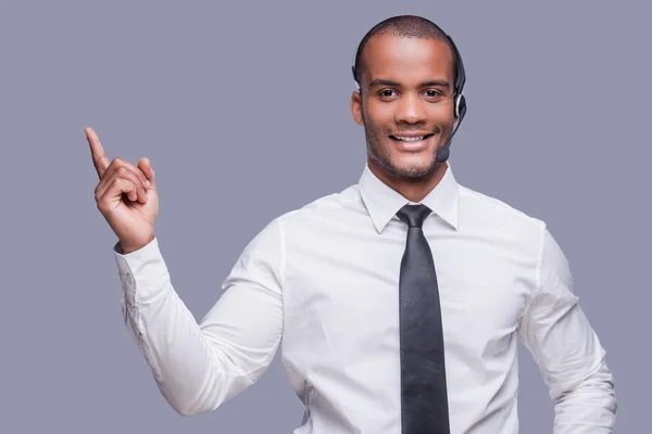 Afrikaanse man in hoofdtelefoon wijzen weg — Stockfoto