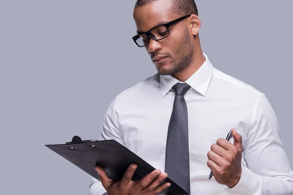 Hombre africano con camisa y corbata sujetando portapapeles — Foto de Stock