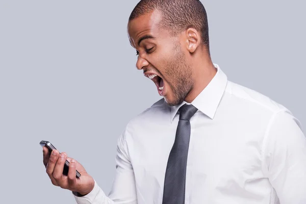 Africano homem de camisa segurando telefone celular e gritando — Fotografia de Stock