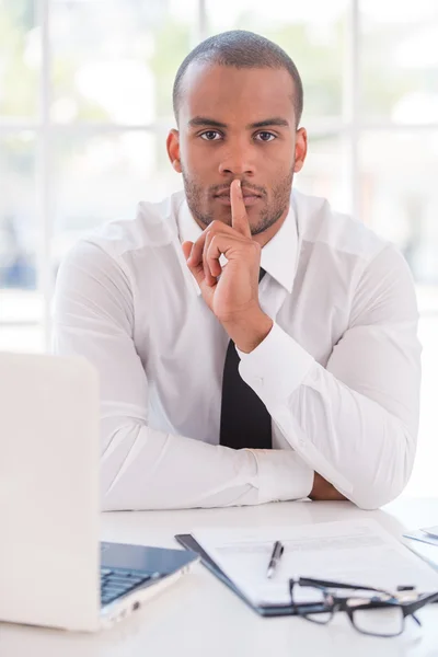 African man in shirt and tie holding finger on lips — Stock Photo, Image