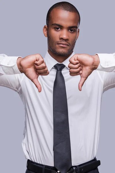 Afrikaanse man in overhemd en stropdas tonen duimen naar beneden Stockfoto