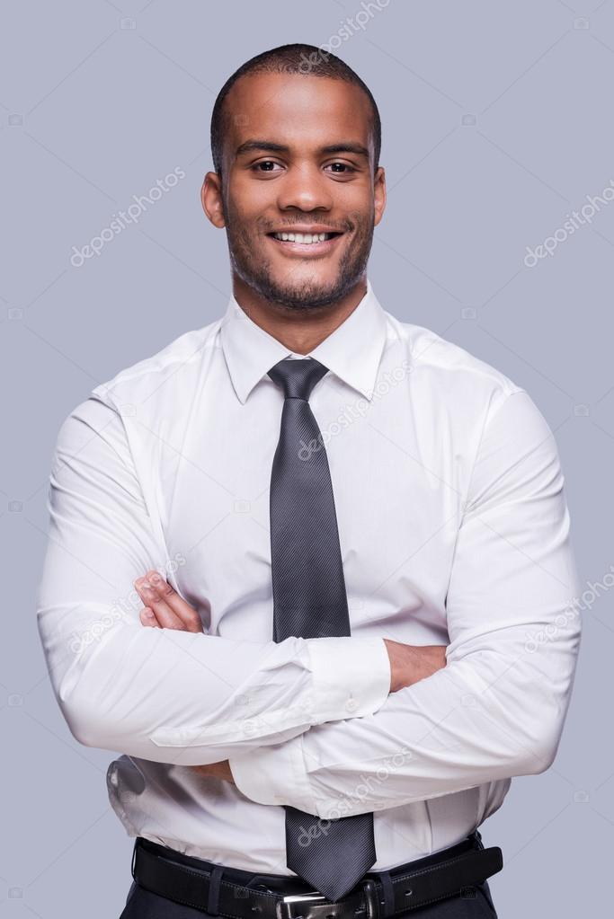 African man in shirt and tie keeping arms crossed