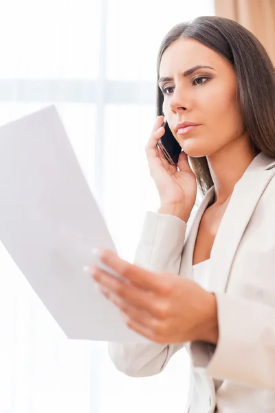 Бізнес-леді розмовляє по телефону і тримає документ — стокове фото